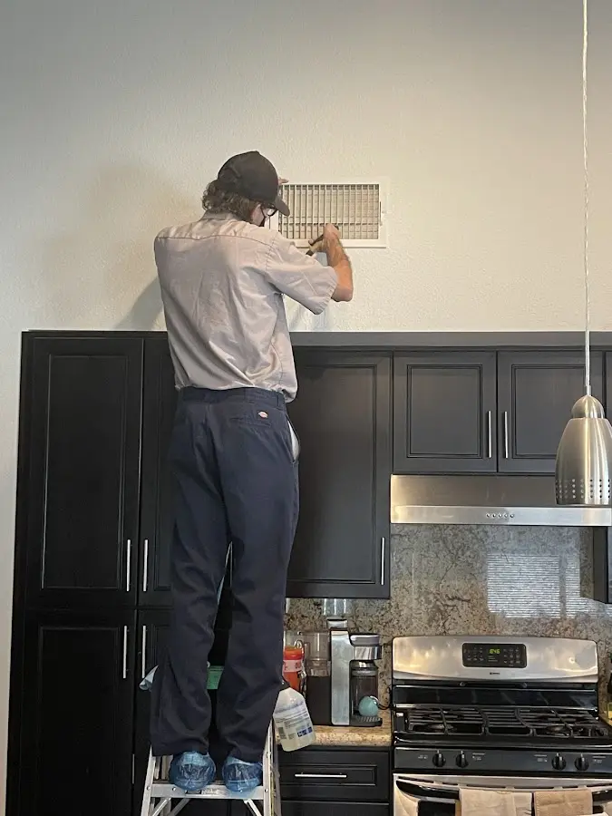 Technician inspecting an air vent during HVAC service in Cedarburg